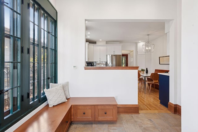 interior space with a chandelier, baseboards, stone finish floor, and recessed lighting