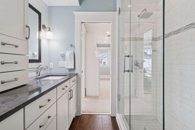 full bathroom featuring a stall shower, wood finished floors, and vanity