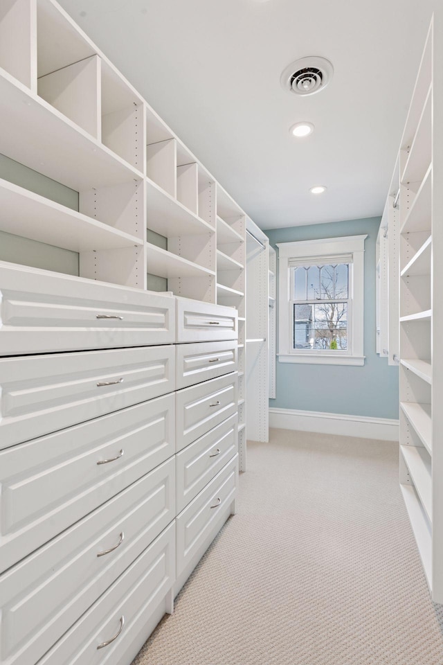 walk in closet with visible vents and light carpet