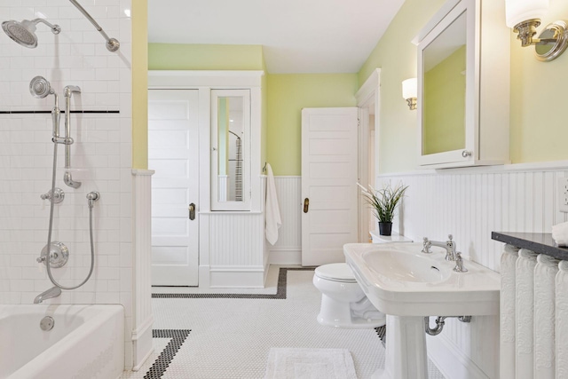 bathroom with shower / bathtub combination, a wainscoted wall, toilet, and tile patterned flooring