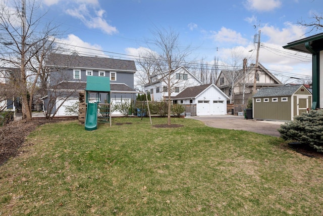 view of front of house featuring a front yard, a garage, an outdoor structure, a residential view, and a playground