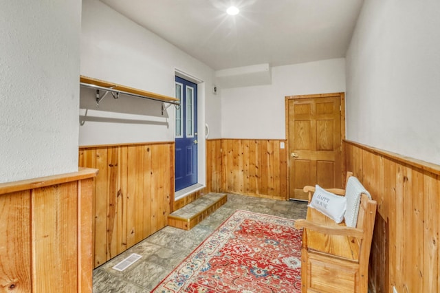 interior space with visible vents, wood walls, and wainscoting