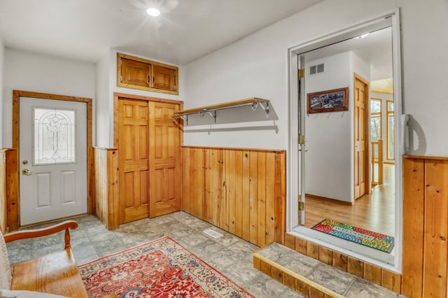 mudroom featuring a wainscoted wall, wood walls, and visible vents
