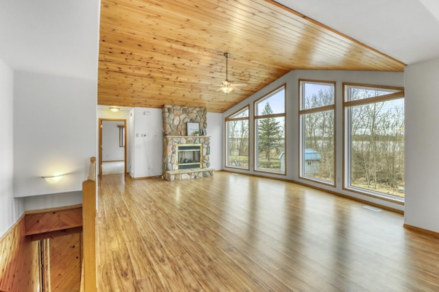 unfurnished living room featuring wood finished floors, a stone fireplace, wooden ceiling, a ceiling fan, and vaulted ceiling