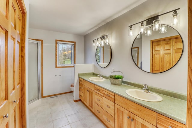 full bathroom with double vanity, tile patterned flooring, a shower stall, a sink, and toilet