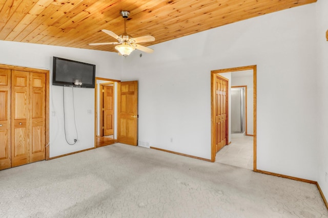 unfurnished bedroom with light colored carpet, baseboards, and wood ceiling