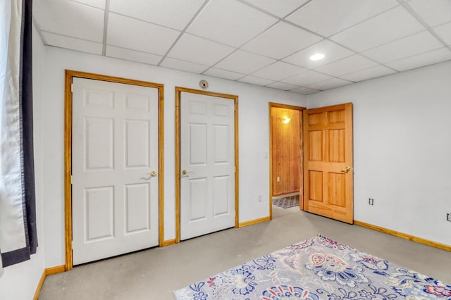 unfurnished bedroom with baseboards and a paneled ceiling