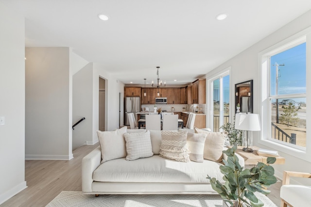 10124 Arrowwood Trl, Woodbury, MN 55129 - living area featuring light wood finished floors, a chandelier, baseboards, and recessed lighting