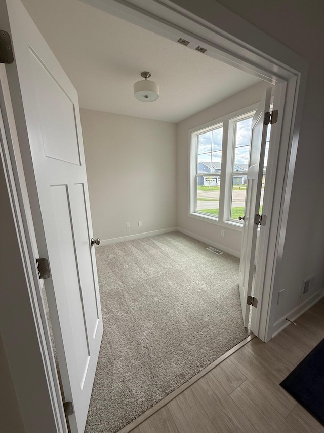 10124 Arrowwood Trl, Woodbury, MN 55129 - carpeted spare room featuring baseboards and wood finished floors
