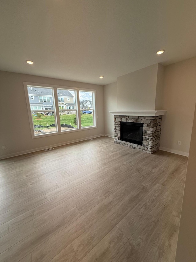 10124 Arrowwood Trl, Woodbury, MN 55129 - unfurnished living room with wood finished floors, recessed lighting, a stone fireplace, and baseboards