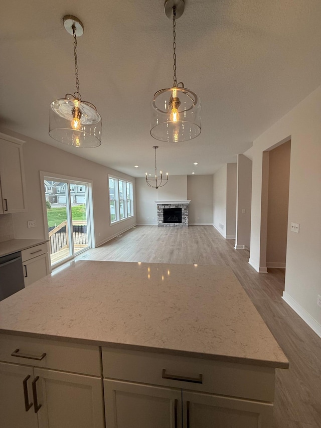 10124 Arrowwood Trl, Woodbury, MN 55129 - kitchen with wood finished floors, open floor plan, baseboards, a center island, and white cabinets