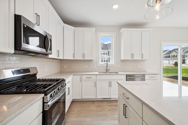 10124 Arrowwood Trl, Woodbury, MN 55129 - kitchen with stainless steel appliances, a sink, healthy amount of natural light, white cabinets, and recessed lighting