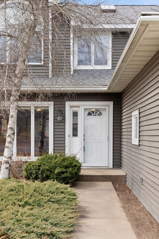 property entrance featuring a shingled roof