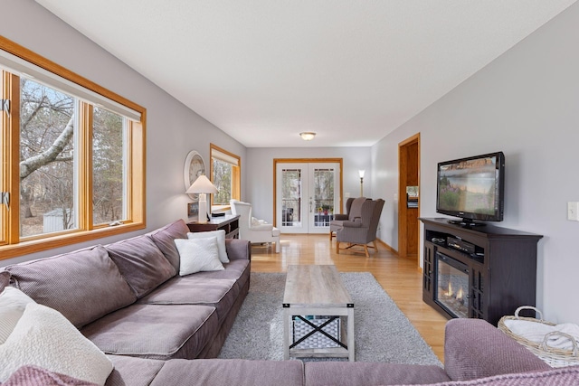 515 Greaton Rd, New Richmond, WI 54017 - living room featuring light wood finished floors, a glass covered fireplace, and french doors