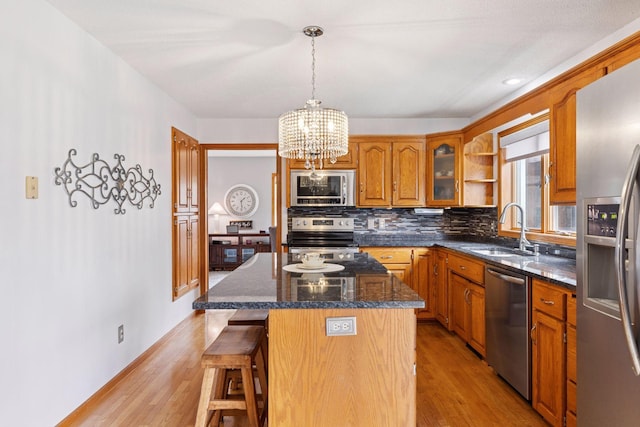515 Greaton Rd, New Richmond, WI 54017 - kitchen with stainless steel appliances, brown cabinets, a chandelier, a center island, and a breakfast bar area