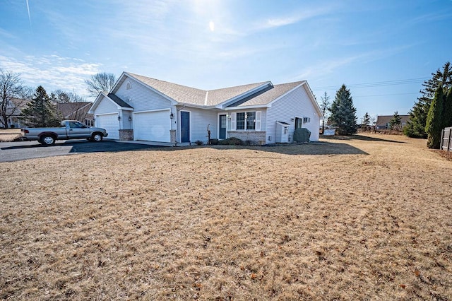 ranch-style home with a front lawn, a garage, and aphalt driveway