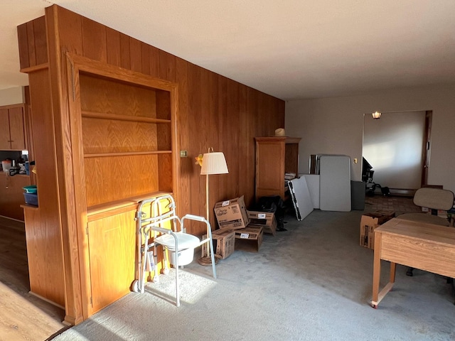 carpeted living room featuring wooden walls