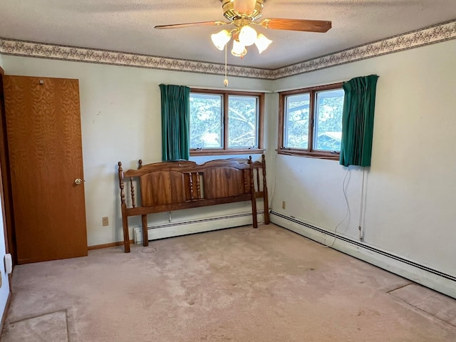 carpeted bedroom with a baseboard radiator, a textured ceiling, and ceiling fan