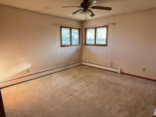 spare room with a baseboard heating unit, ceiling fan, baseboards, and light colored carpet