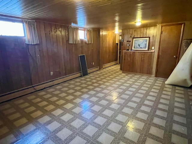 basement with baseboard heating, wood walls, a wealth of natural light, and wooden ceiling