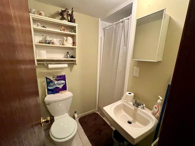 bathroom featuring tile patterned flooring, a shower with curtain, toilet, and a sink