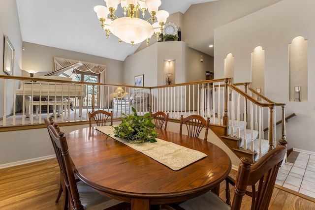 13162 Glenhaven Ave, Apple Valley, MN 55124 - dining room with a chandelier, stairway, baseboards, wood finished floors, and high vaulted ceiling