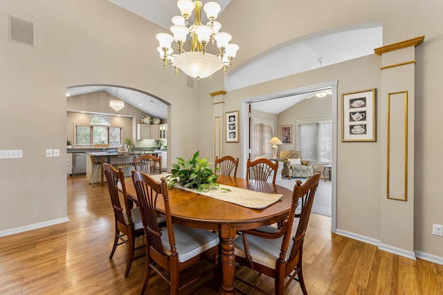 13162 Glenhaven Ave, Apple Valley, MN 55124 - dining space with vaulted ceiling, arched walkways, healthy amount of natural light, light wood-type flooring, and a chandelier