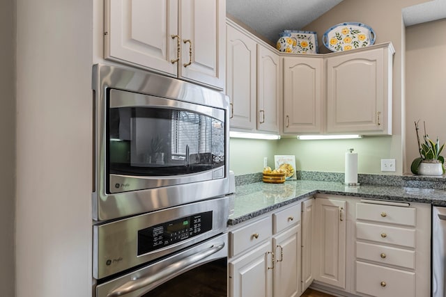 13162 Glenhaven Ave, Apple Valley, MN 55124 - kitchen with appliances with stainless steel finishes, a textured ceiling, stone countertops, white cabinets, and lofted ceiling
