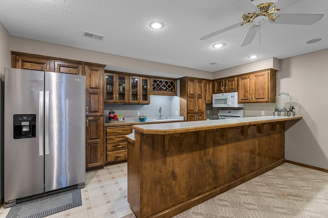 13162 Glenhaven Ave, Apple Valley, MN 55124 - kitchen featuring white appliances, a peninsula, ceiling fan, light flooring, and glass insert cabinets