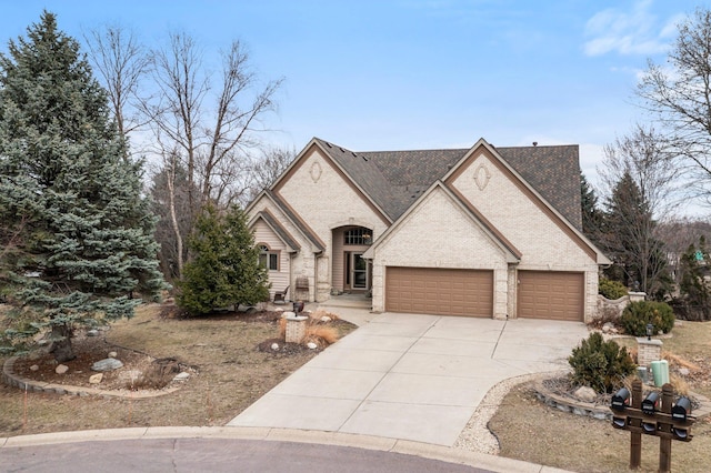 13162 Glenhaven Ave, Apple Valley, MN 55124 - french country home with concrete driveway, an attached garage, brick siding, and roof with shingles