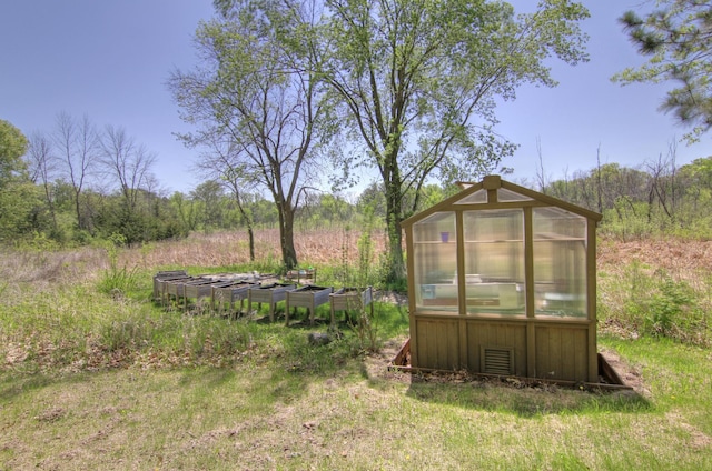 view of yard featuring an exterior structure, an outbuilding, and a garden