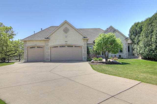 view of front of property with stucco siding, an attached garage, driveway, and a shingled roof