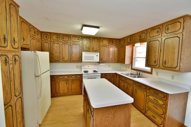 18045 Delaware Ln, Eden Lake Twp, MN 56362 - kitchen featuring white appliances, brown cabinetry, a sink, light wood-type flooring, and a textured ceiling