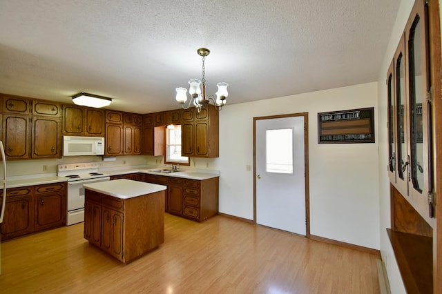 18045 Delaware Ln, Eden Lake Twp, MN 56362 - kitchen with white appliances, a sink, a chandelier, light countertops, and light wood finished floors