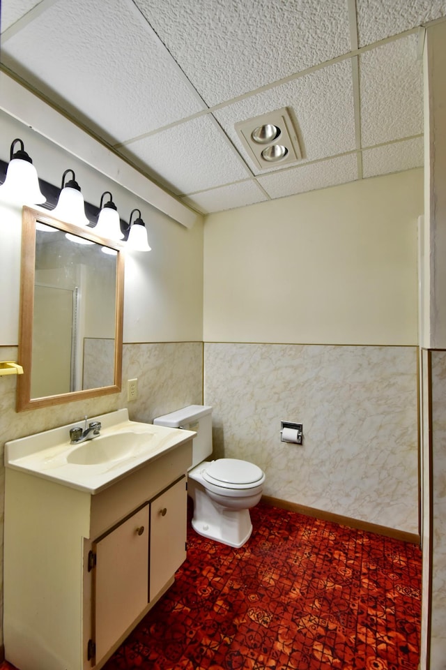 18045 Delaware Ln, Eden Lake Twp, MN 56362 - bathroom featuring toilet, a wainscoted wall, tile patterned floors, vanity, and tile walls