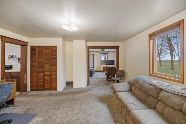 carpeted living area featuring ceiling fan