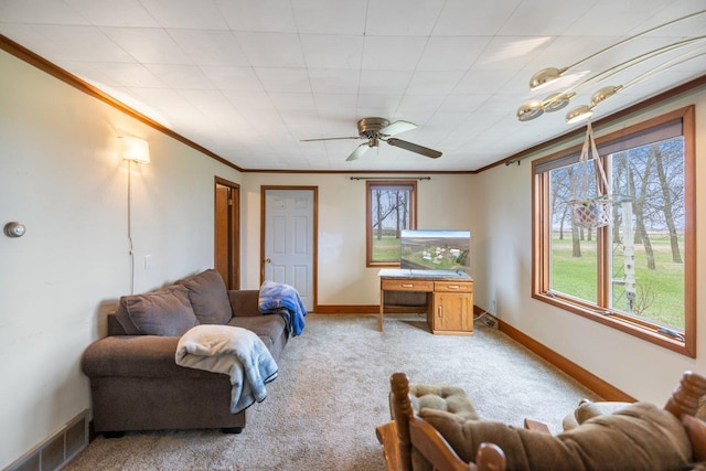 living area featuring visible vents, a healthy amount of sunlight, crown molding, and light carpet