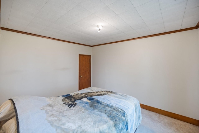bedroom featuring baseboards, ornamental molding, and carpet flooring