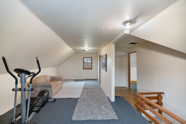 exercise room with visible vents, carpet floors, and vaulted ceiling