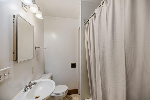 full bath featuring curtained shower, toilet, baseboards, and a sink