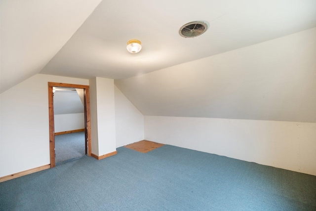 additional living space with visible vents, vaulted ceiling, and carpet floors