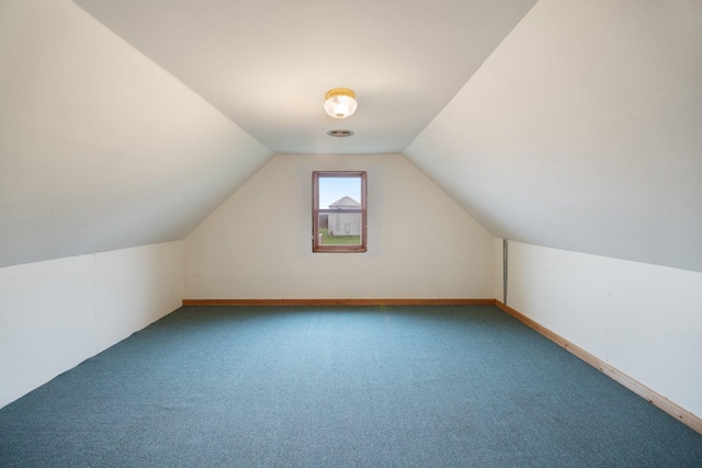 additional living space with vaulted ceiling and carpet