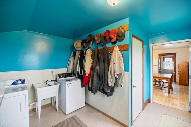 clothes washing area featuring baseboards, washing machine and clothes dryer, laundry area, and light floors