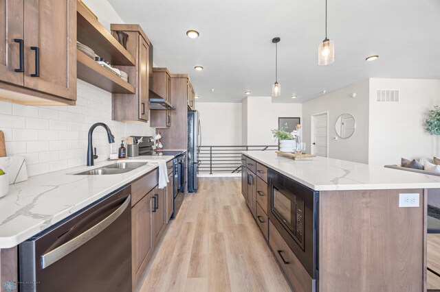 kitchen with visible vents, a center island, light wood-type flooring, a sink, and stainless steel appliances