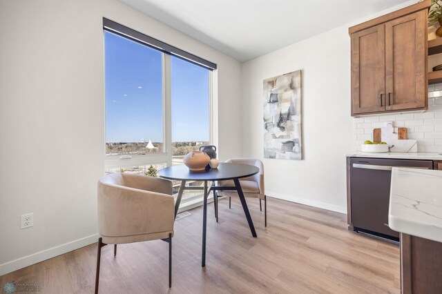 dining area with baseboards and light wood-style floors