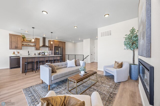 living area with visible vents, recessed lighting, and light wood-style floors