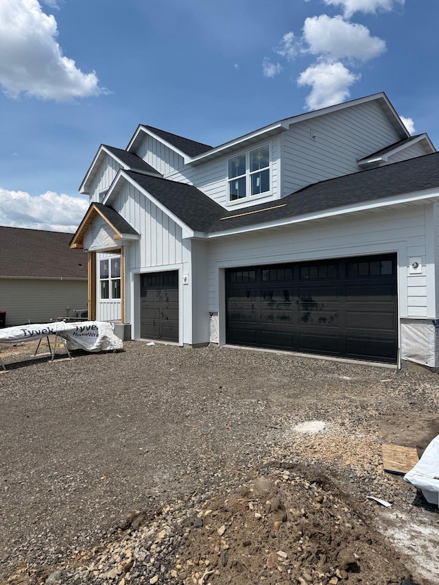 10155 Arrowwood Trl, Woodbury, MN 55129 - modern inspired farmhouse with dirt driveway, board and batten siding, a shingled roof, and an attached garage