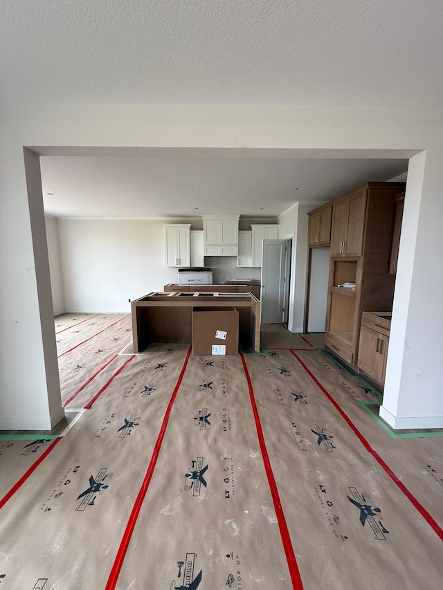 10155 Arrowwood Trl, Woodbury, MN 55129 - kitchen with a center island, baseboards, white cabinets, and a textured ceiling