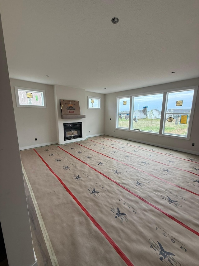 10155 Arrowwood Trl, Woodbury, MN 55129 - unfurnished living room with baseboards and a glass covered fireplace