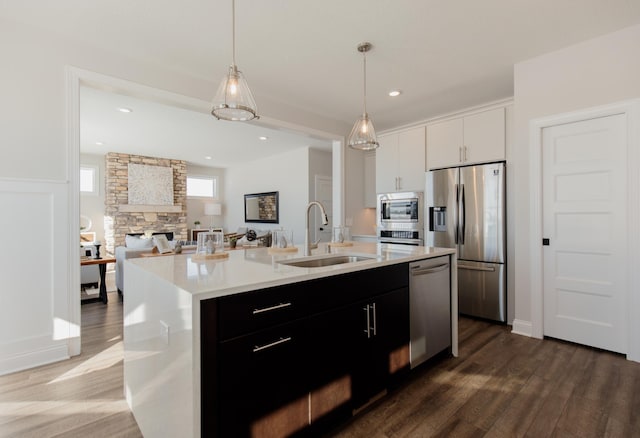 10155 Arrowwood Trl, Woodbury, MN 55129 - kitchen with appliances with stainless steel finishes, a sink, dark wood-style flooring, light countertops, and hanging light fixtures